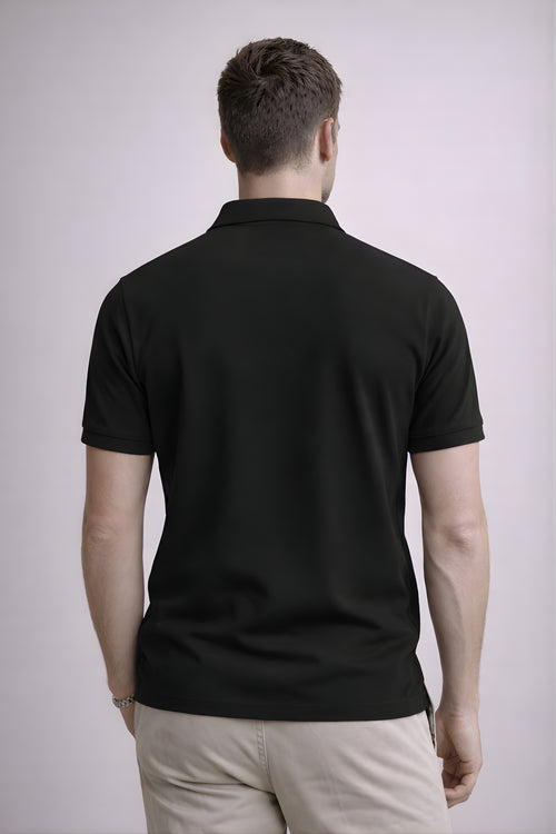 Man wearing a black polo shirt on a plain background