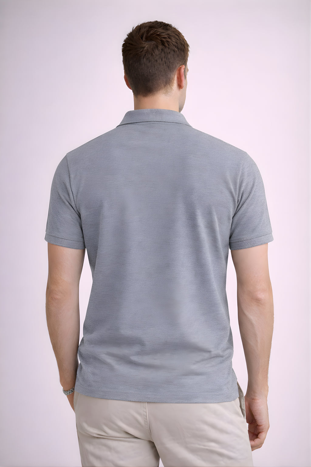 Man wearing a light gray polo shirt on a white background