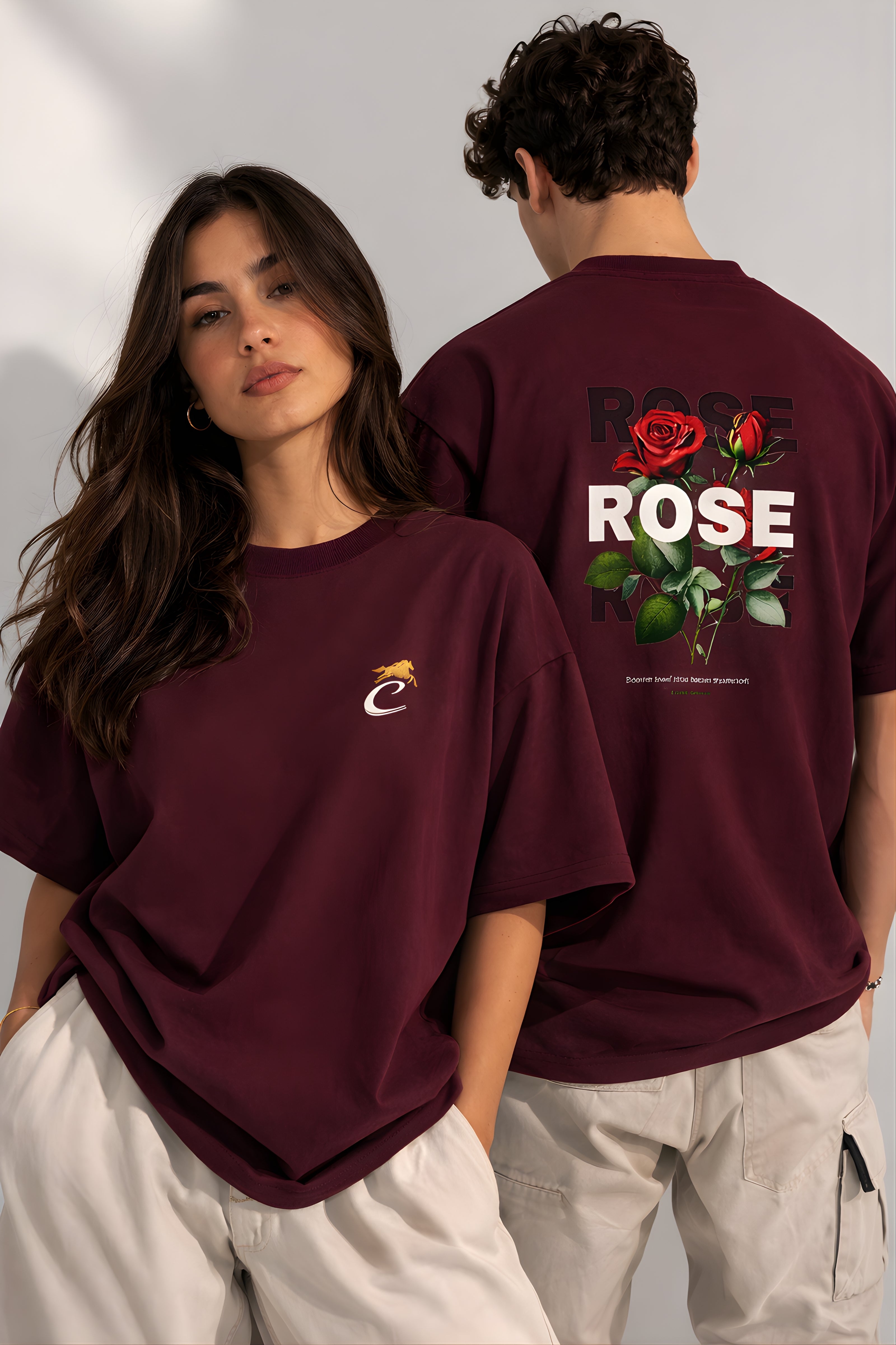 Couple wearing burgundy oversized terry t-shirt with front logo and rose graphic back print streetwear fashion